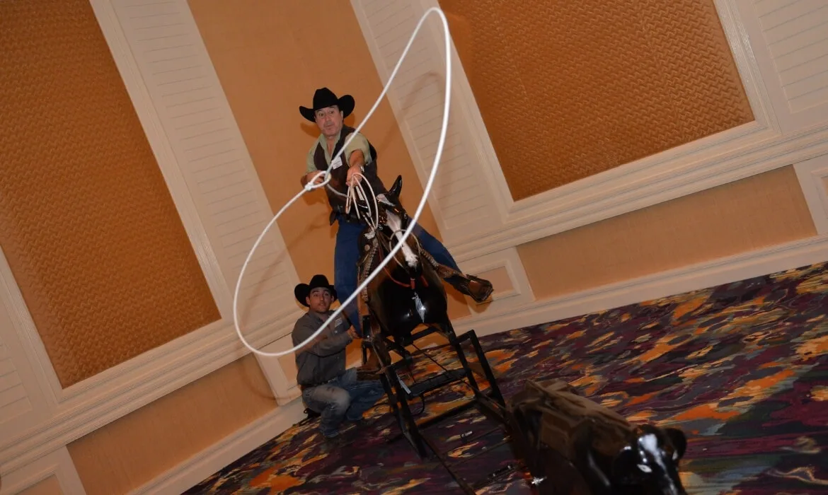 man demonstrating on a pretend steer with a rope